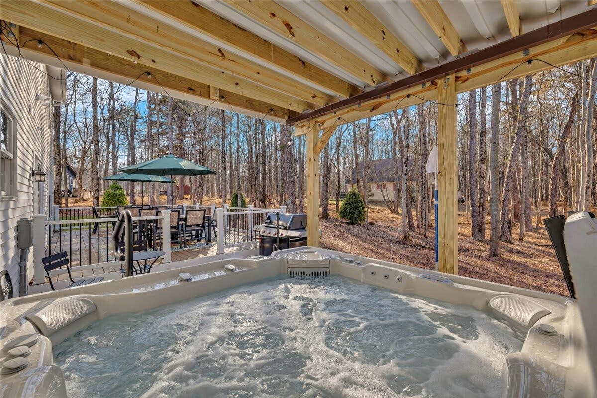 The Happy House | Pocono Vacation Rental | Elevate your stay with the perfect duo: BBQ delights and hot tub relaxation on our outdoor deck}